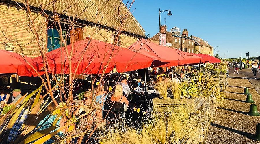 Outdoor restaurant seating beneath red parasols
