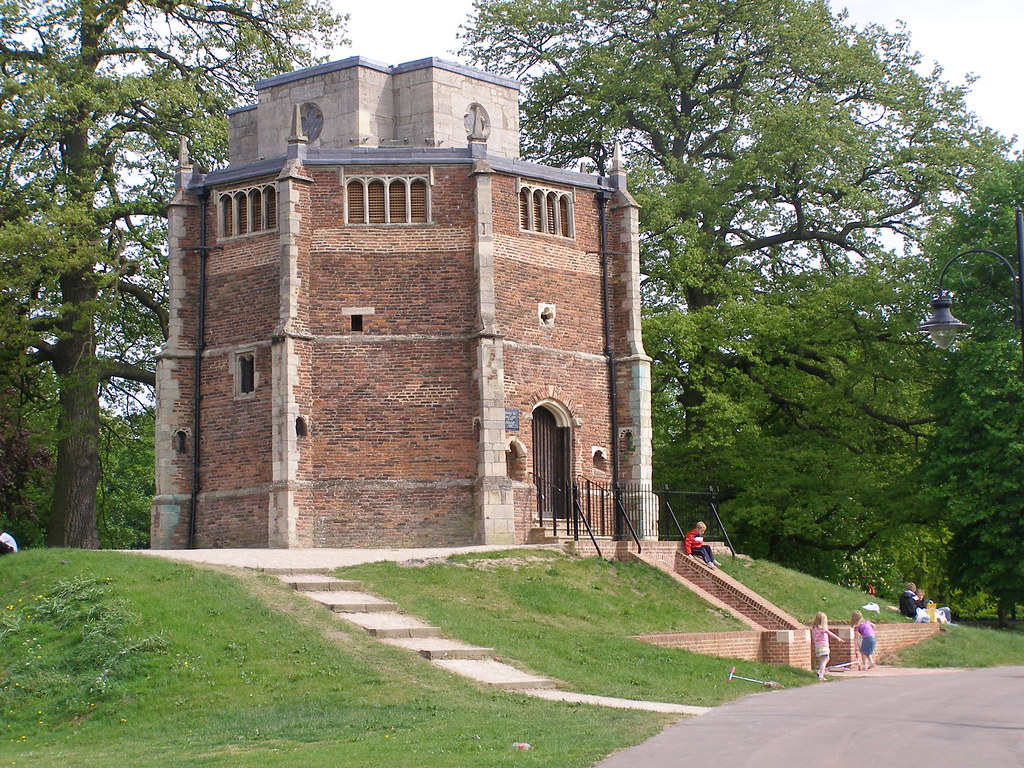 Red brick chapel beside a path and mature trees